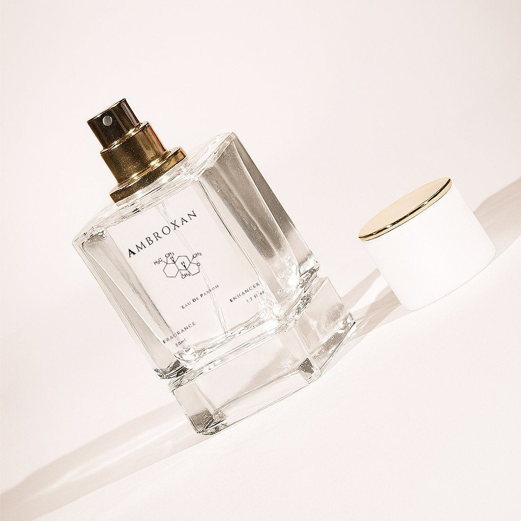 LeScent Perfume Primer bottle of Ambroxan with gold spray cap, photographed on a light background
