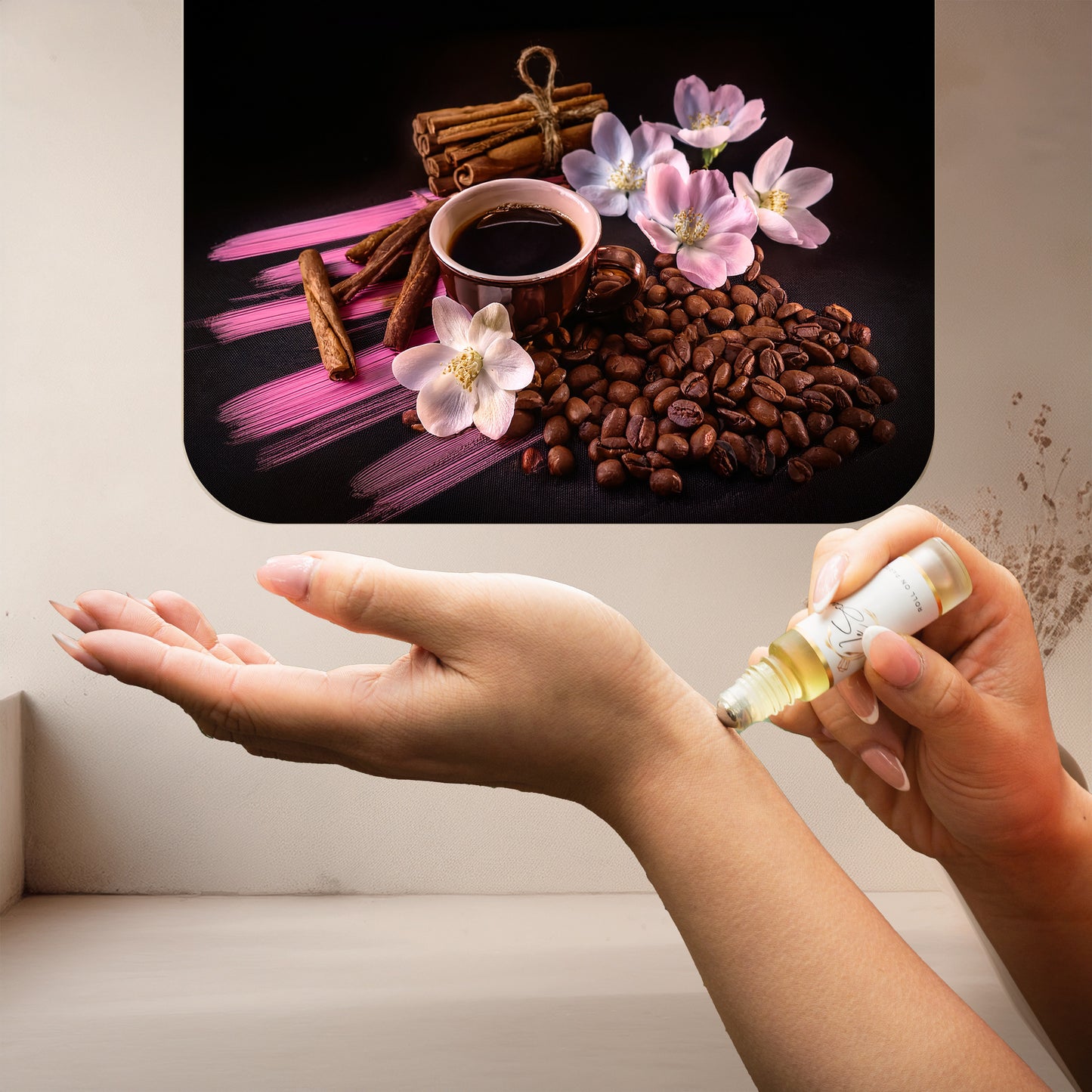Applying LeScent Vanille Café roll-on perfume oil beside roasted coffee beans, cinnamon sticks, and pink floral accents, inspired by Yves Saint Laurent Black Opium.