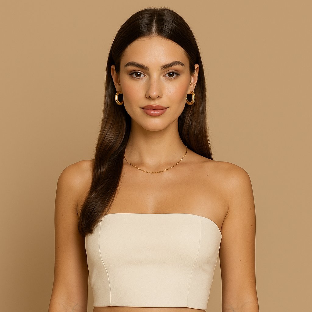 Portrait of a woman with sleek brown hair wearing a strapless beige top and gold earrings, representing the LeScent Women’s Fragrance Collection