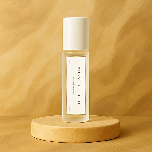 LeScent 8oss Bottled perfume oil roll-on bottle on a sand-colored pedestal with a wavy sand background, inspired by Boss Bottled.
