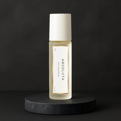 LeScent Absoluta roll-on perfume oil bottle displayed on a sleek black pedestal with soft light reflection, inspired by Creed Aventus Absolu.