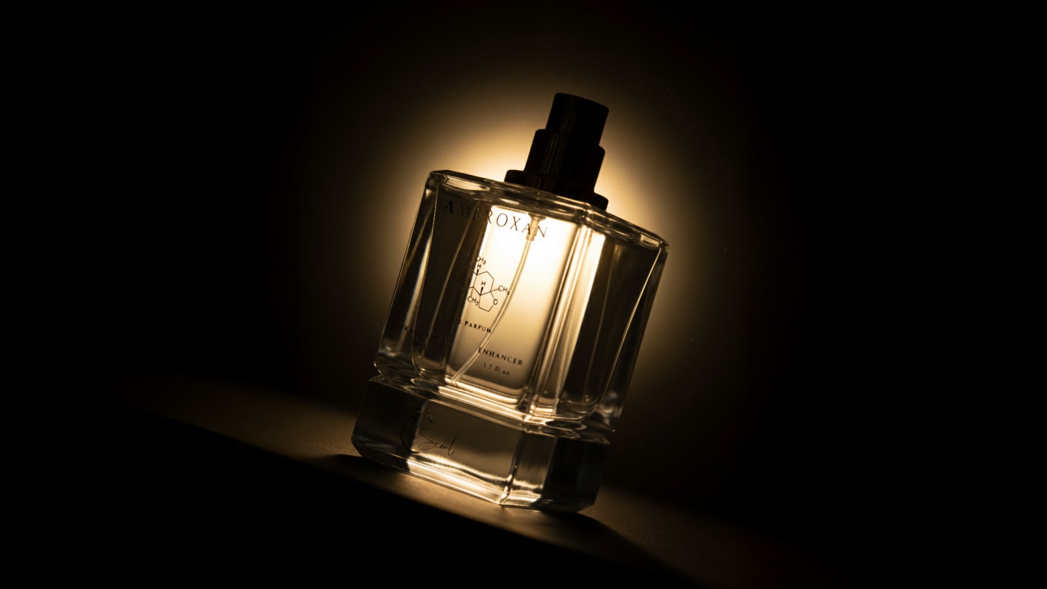 LeScent Ambroxan fragrance enhancer perfume primer spray bottle in a moody warm backlit product photo, long-lasting layering scent, inspired by Ambroxan.