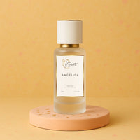 LeScent Angelica hair fragrance mist bottle displayed on a peach pedestal with soft golden lighting and warm beige background, inspired by Yves Saint Laurent Supreme Bouquet.