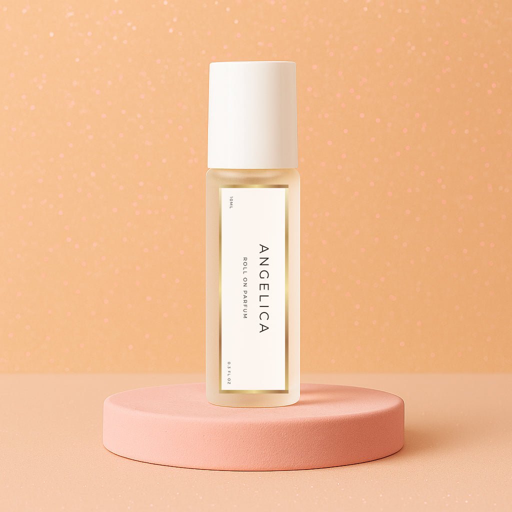 LeScent Angelica roll-on perfume oil bottle standing on a soft peach platform with sparkled background lighting, inspired by Yves Saint Laurent Supreme Bouquet.