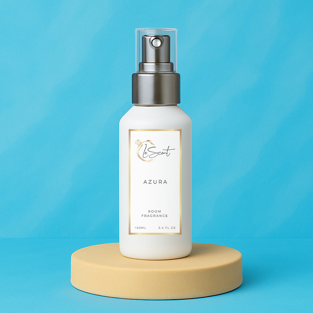 LeScent Azura room fragrance spray bottle presented on a beige pedestal against a smooth sky-blue background with soft natural lighting, inspired by Tom Ford Costa Azzurra.