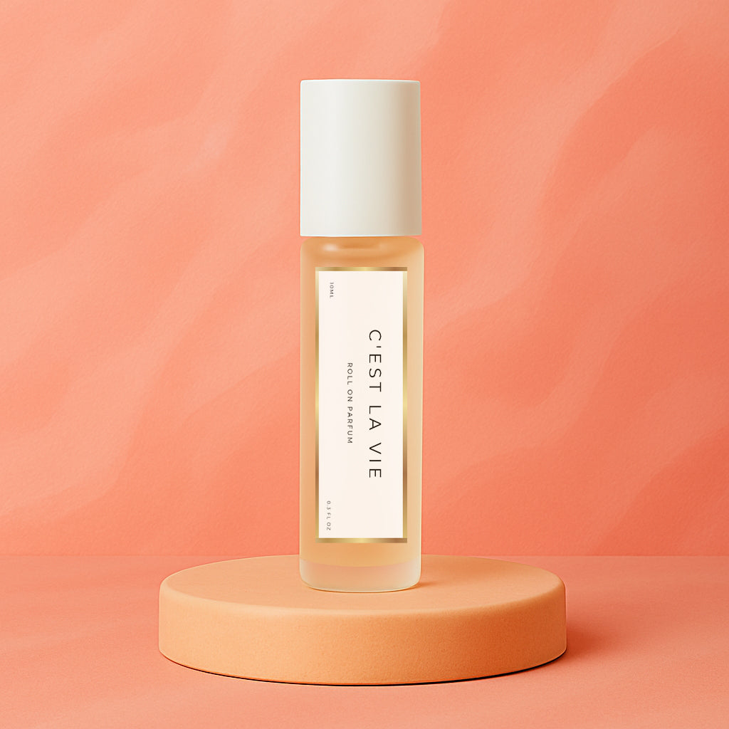 LeScent C’est La Vie roll-on perfume oil and parfum oil roller bottle on a soft coral background, premium long lasting perfume oil inspired by Lancôme La Vie Est Belle.
