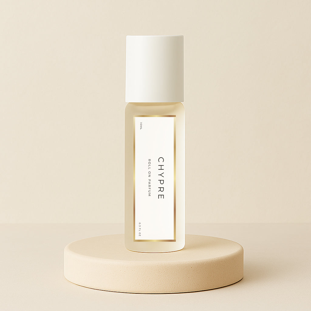 LeScent Chypre roll-on perfume oil bottle displayed on a soft beige pedestal with warm neutral background and golden tones, inspired by Nishane Hacivat.