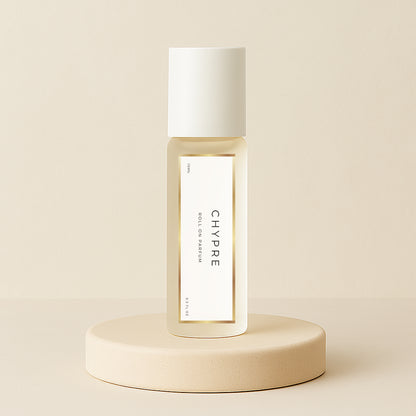 LeScent Chypre roll-on perfume oil bottle displayed on a soft beige pedestal with warm neutral background and golden tones, inspired by Nishane Hacivat.