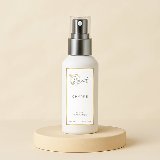 White room fragrance bottle with silver spray top on a beige platform against a beige background