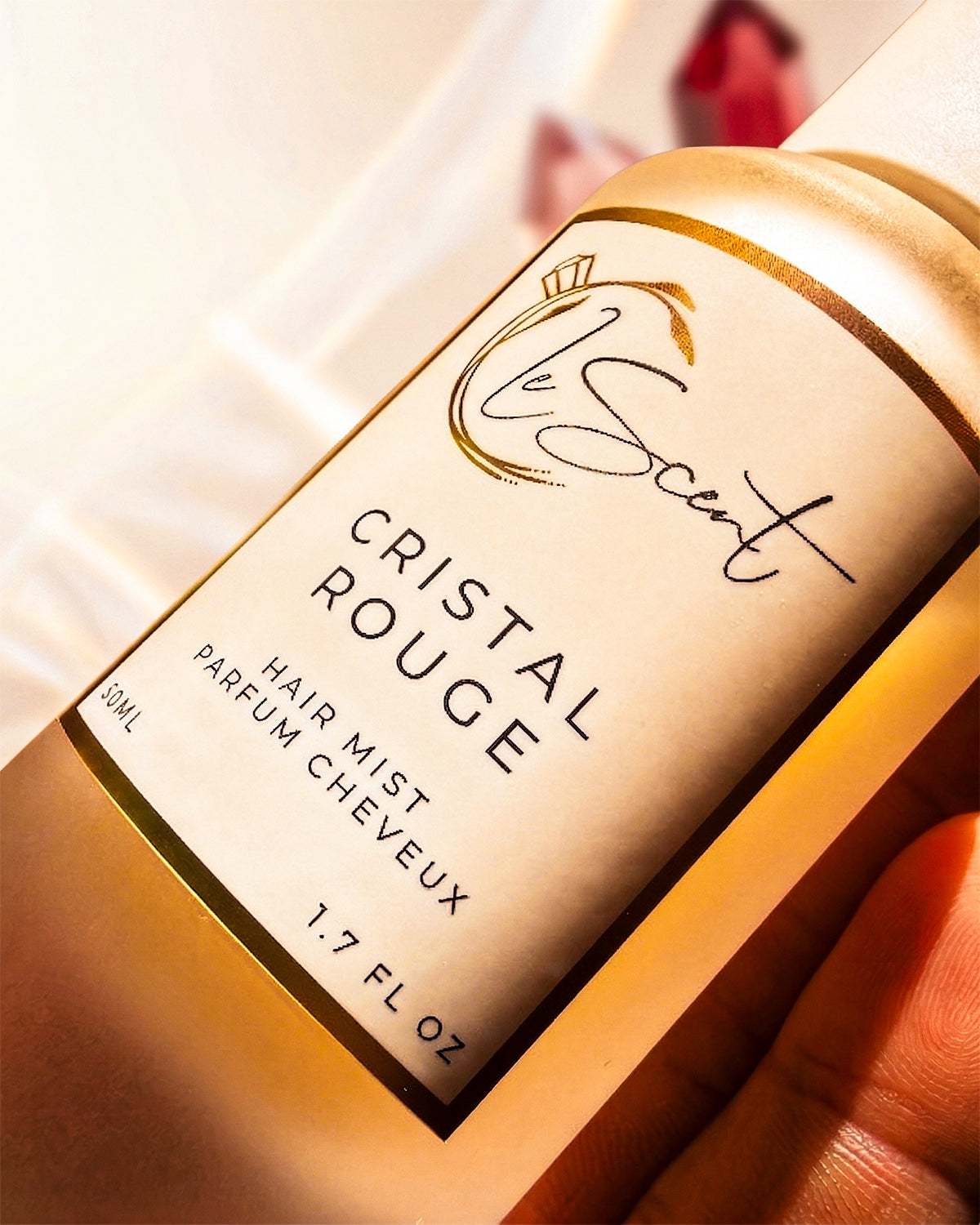 Close-up of LeScent Cristal Rouge hair mist and hair perfume with warm, golden lighting.