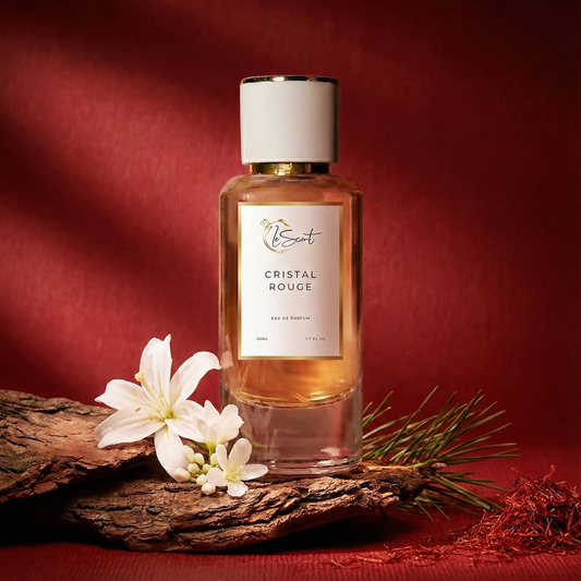 LeScent Cristal Rouge inspired perfume bottle placed on natural wood with white flowers, pine and saffron on a rich red background. Inspired by MFK Baccarat Rouge 540.