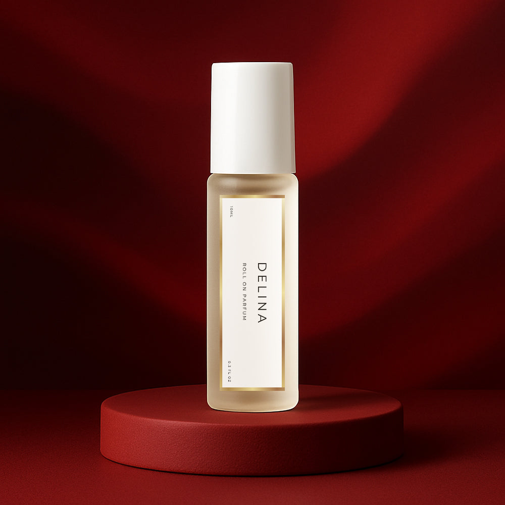 LeScent Delina roll-on perfume oil bottle standing on a deep red pedestal with a rich crimson backdrop and soft studio lighting, inspired by Maison Crivelli Hibiscus Mahajad.