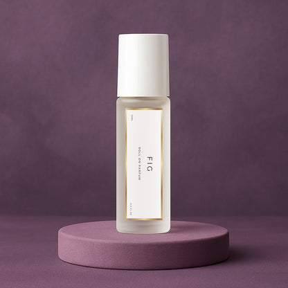 LeScent FIG roll-on perfume oil inspired by Le Labo Thé Noir 29 placed on a soft plum pedestal with a matte plum background.