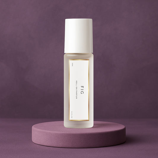LeScent FIG roll-on perfume oil inspired by Le Labo Thé Noir 29 placed on a soft plum pedestal with a matte plum background.