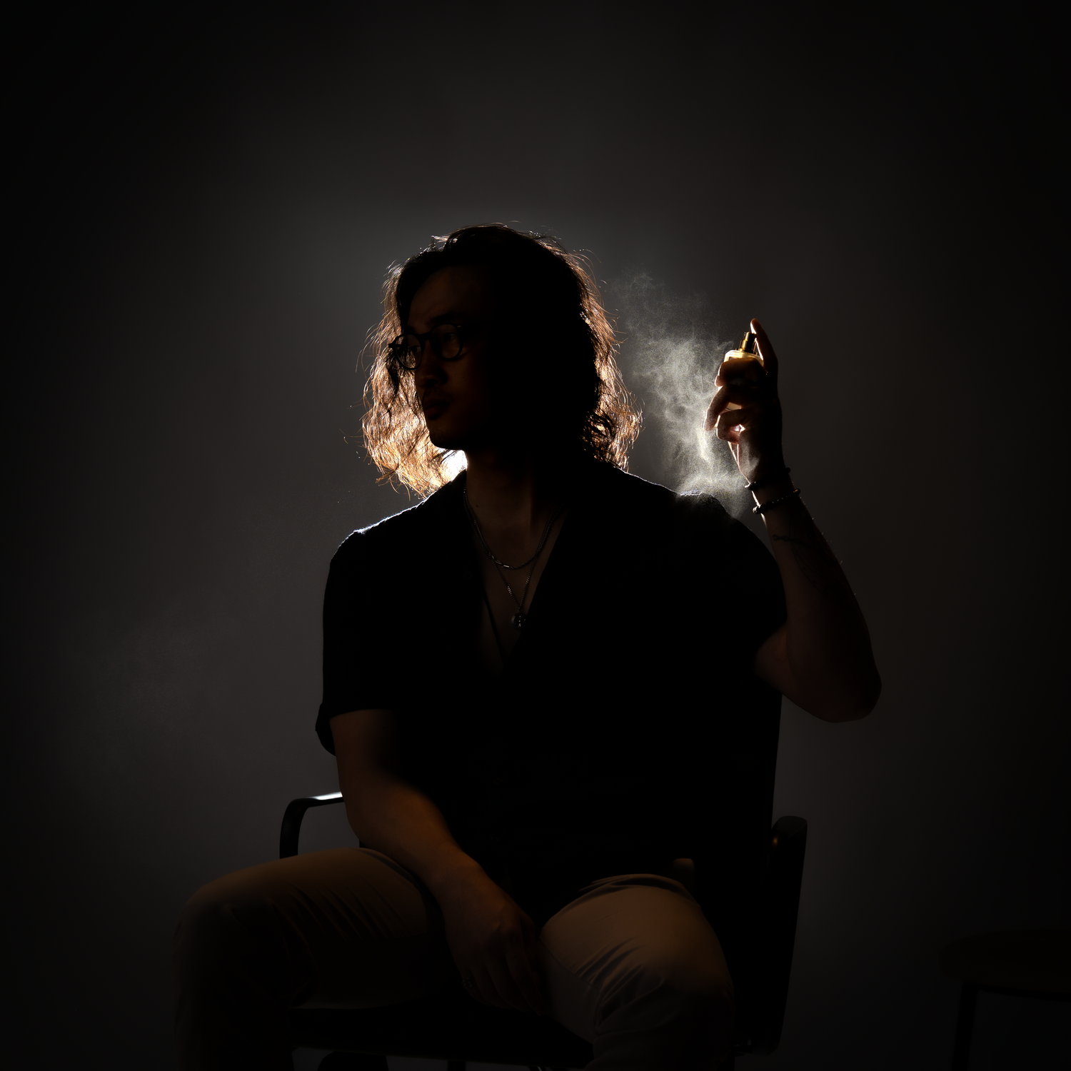 LeScent Co-Founder and indie perfumer Adam holding a fragrance bottle in dramatic lighting — representing the brand’s dedication to innovation, craftsmanship, and personalized scent creation.