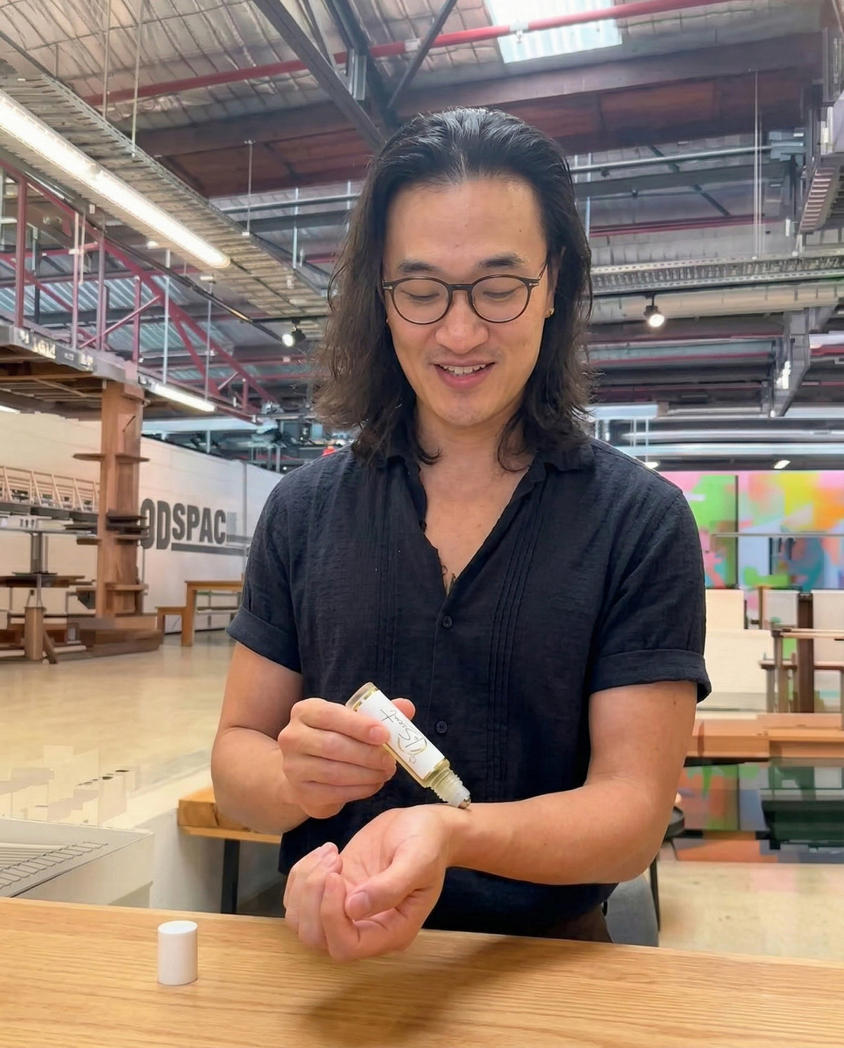 LeScent founder demonstrating Bonaparte roll-on perfume oil layering on wrist