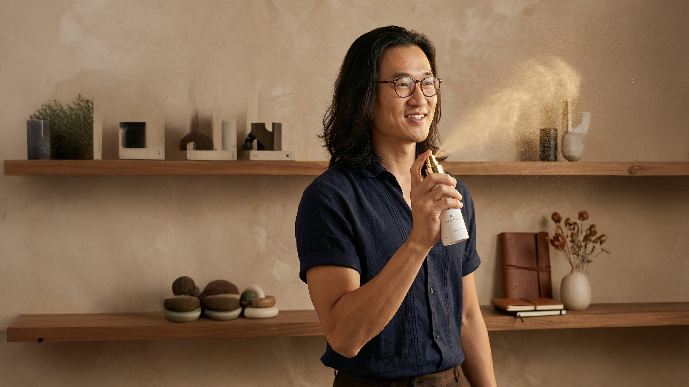 Man holding a bottle in a room with shelves and decor
