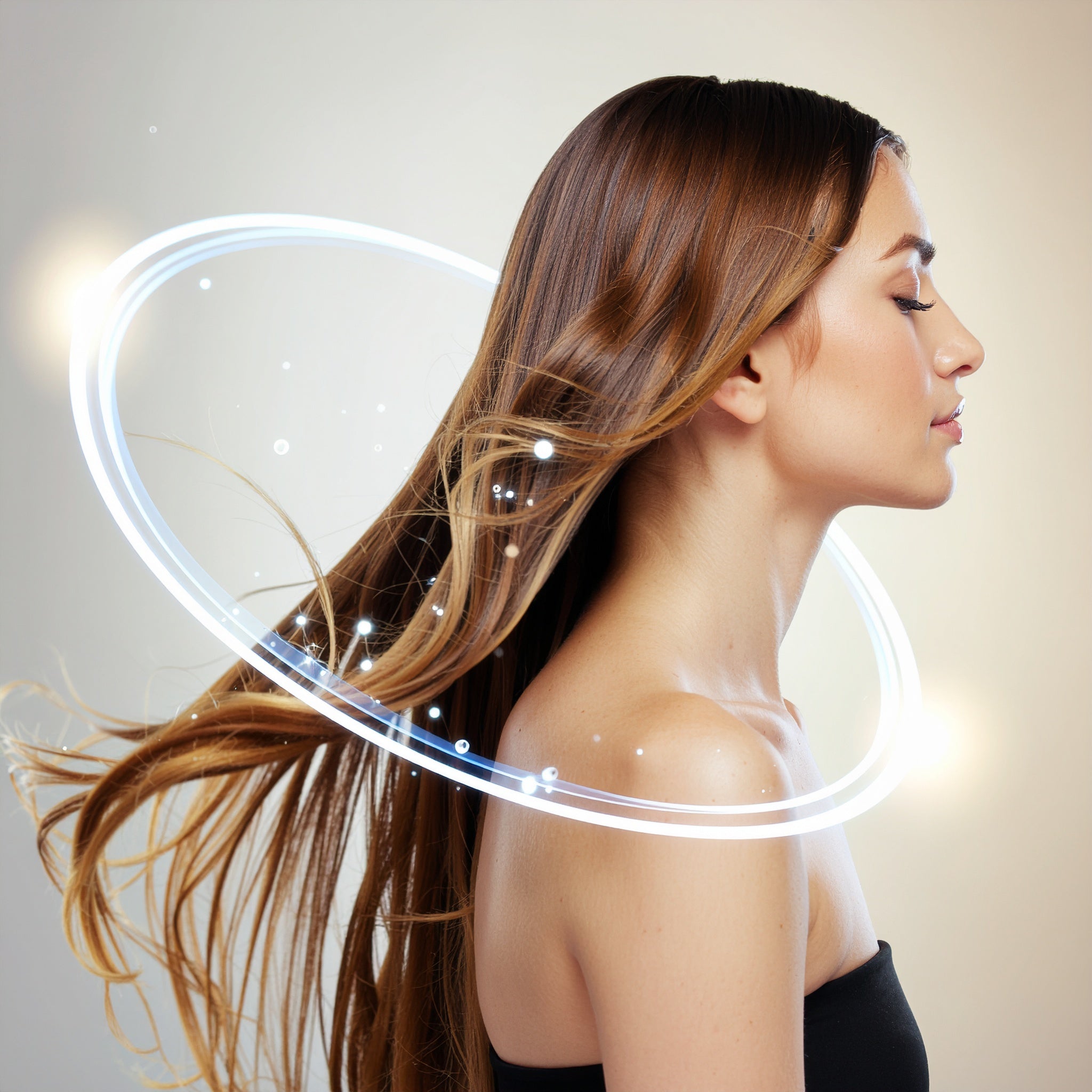 A woman in profile with long, healthy brown hair flowing, surrounded by a glowing orb of light, illustrating the concept of a luxurious hair mist.
