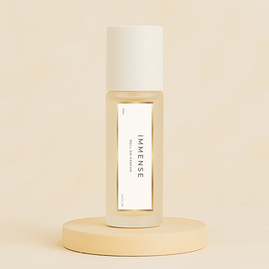 LeScent Immense perfume oil roll-on bottle on a soft beige pedestal with a matching warm beige background, captured as a clean minimal hero shot, inspired by Louis Vuitton L’Immensité.