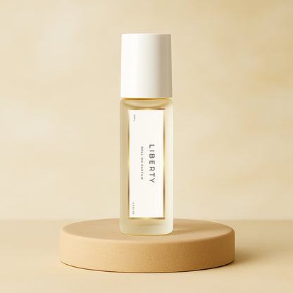 LeScent Liberty roll-on perfume oil bottle standing on a smooth beige pedestal with a soft neutral background and gentle studio lighting, inspired by Yves Saint Laurent Libre.