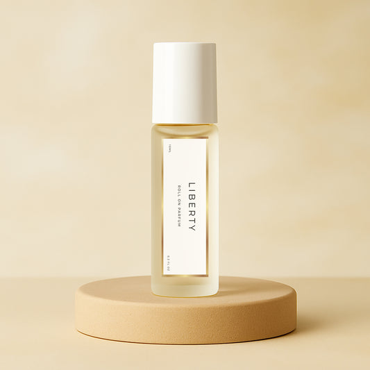 LeScent Liberty roll-on perfume oil bottle standing on a smooth beige pedestal with a soft neutral background and gentle studio lighting, inspired by Yves Saint Laurent Libre.