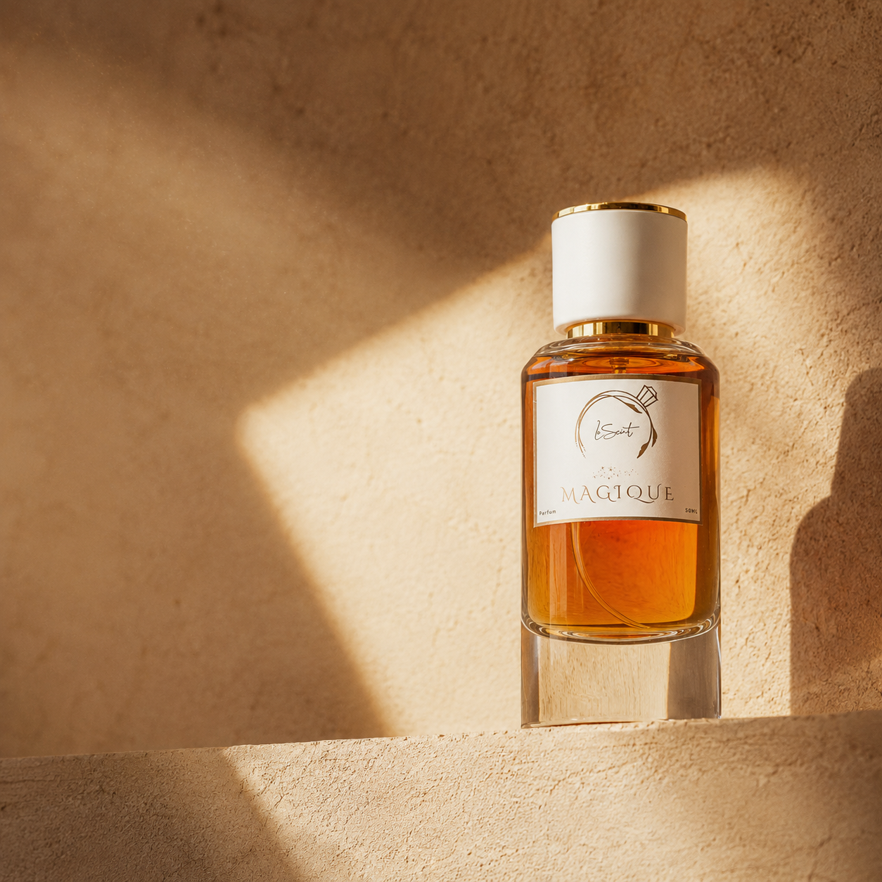 A bottle of LeScent Magique perfume with amber liquid, a white cap, and a white label, set on a textured beige stone surface with dramatic warm sunlight and shadows.