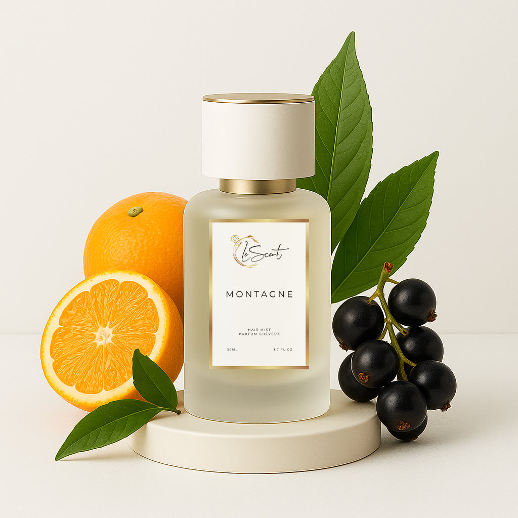 LeScent Montagne hair perfume, hair fragrance, hair perfume mist bottle surrounded by sliced oranges, whole oranges, blackcurrants, and green leaves arranged neatly beside the pedestal, inspired by Creed Silver Mountain Water.