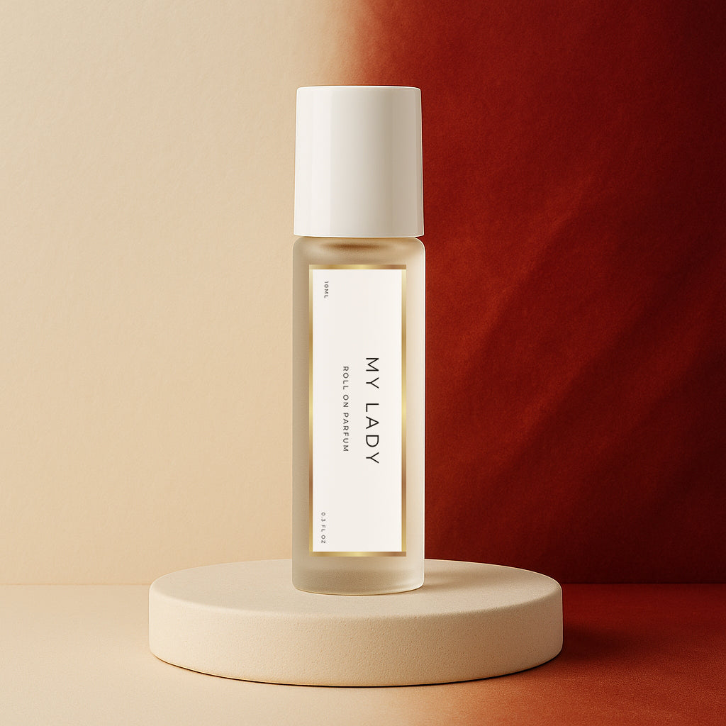 LeScent My Lady roll-on perfume oil bottle standing on a soft cream pedestal with a warm red gradient backdrop and gentle studio lighting, inspired by Frédéric Malle Portrait of a Lady.