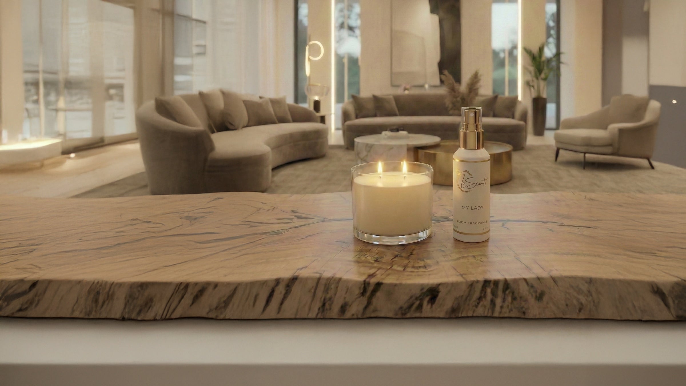 LeScent My Lady room fragrance beside a lit candle on a marble table in a luxury living room interior