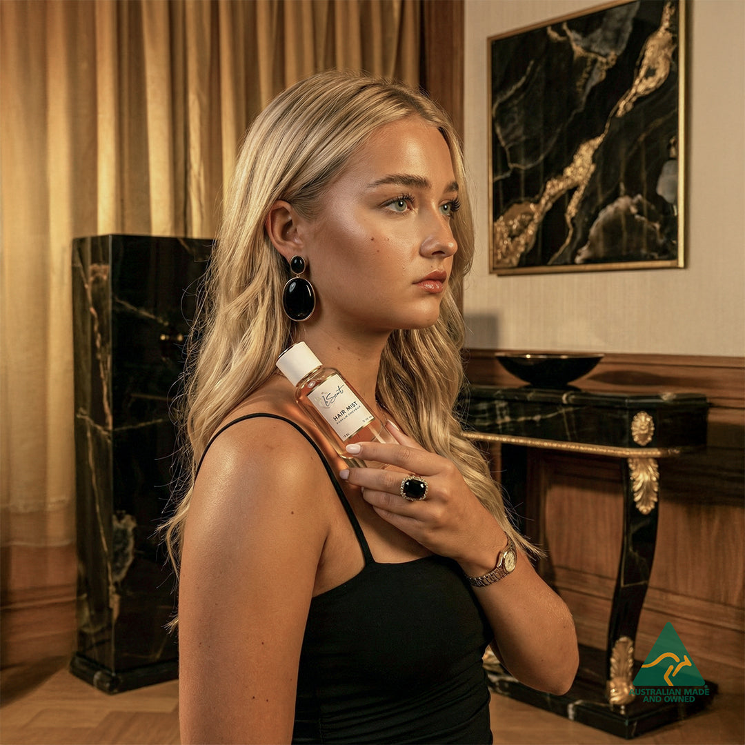 Woman holding LeScent Onyx hair mist bottle in a luxury interior with Australian Made logo, hair perfume, hair fragrance, and hair perfume mist inspired by Onyx.