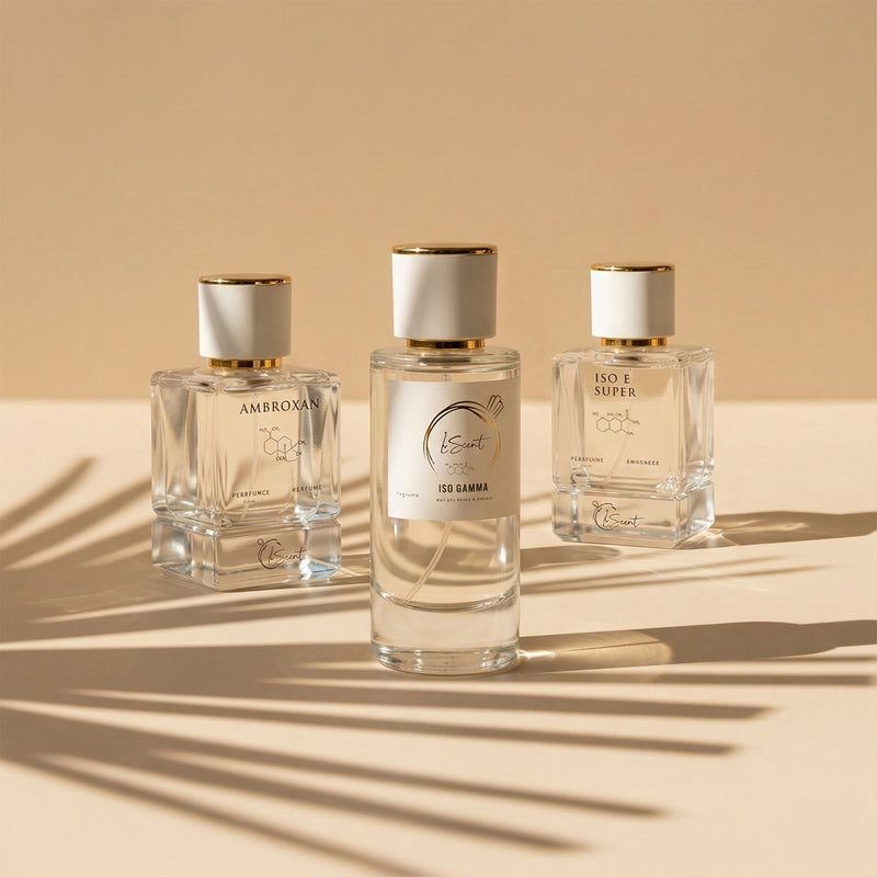 Three glass perfume bottles with white and gold caps sitting on a warm beige surface with cast palm leaf shadows, inspired by LeScent Ambroxan Perfume Primer, LeScent Iso Gamma Perfume Primer, and LeScent Iso E Super Perfume Primer.