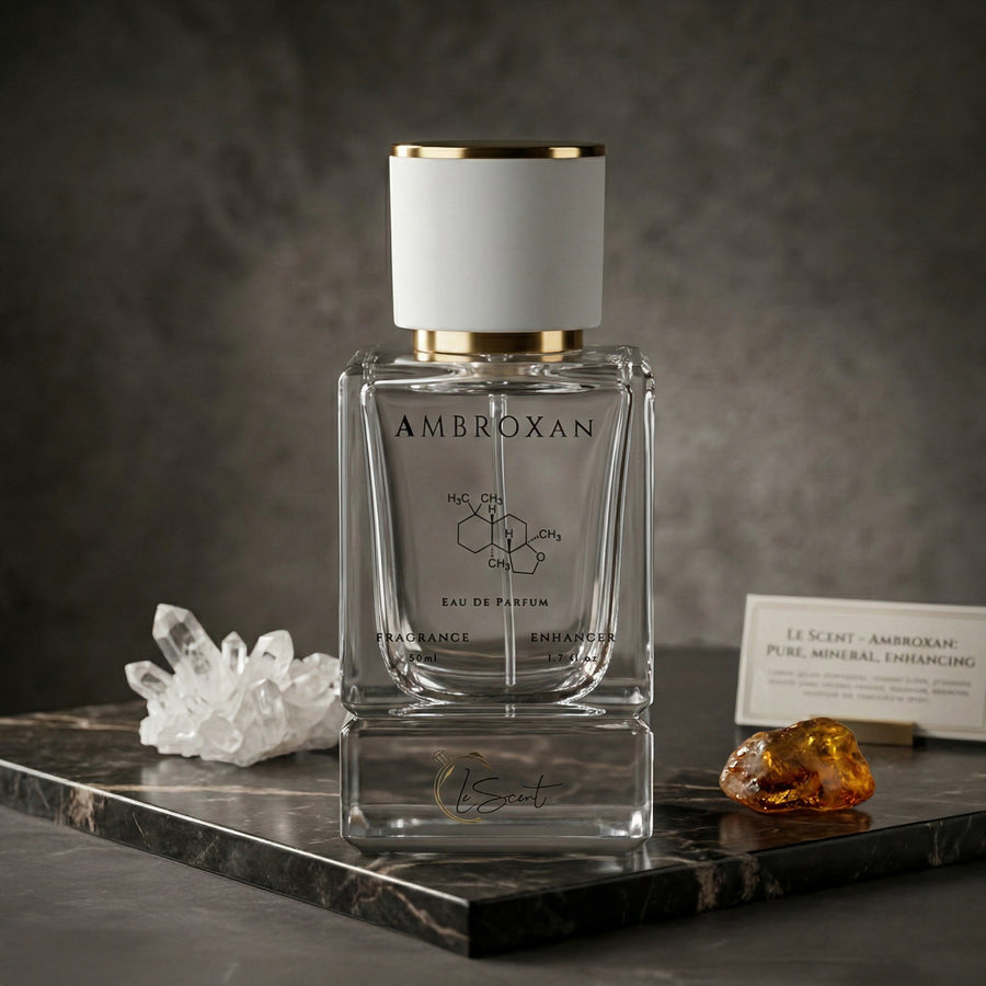 LeScent Ambroxan perfume primer bottle displayed on a dark stone surface with crystal and amber accents in a product photo.