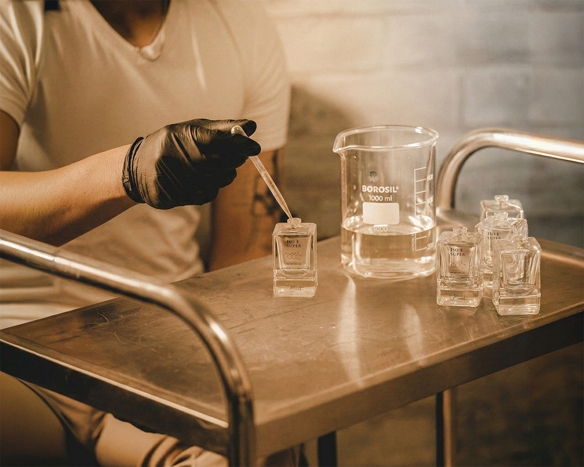Lab scene showing LeScent Iso E Super perfume primer bottle being filled with a pipette during production.
