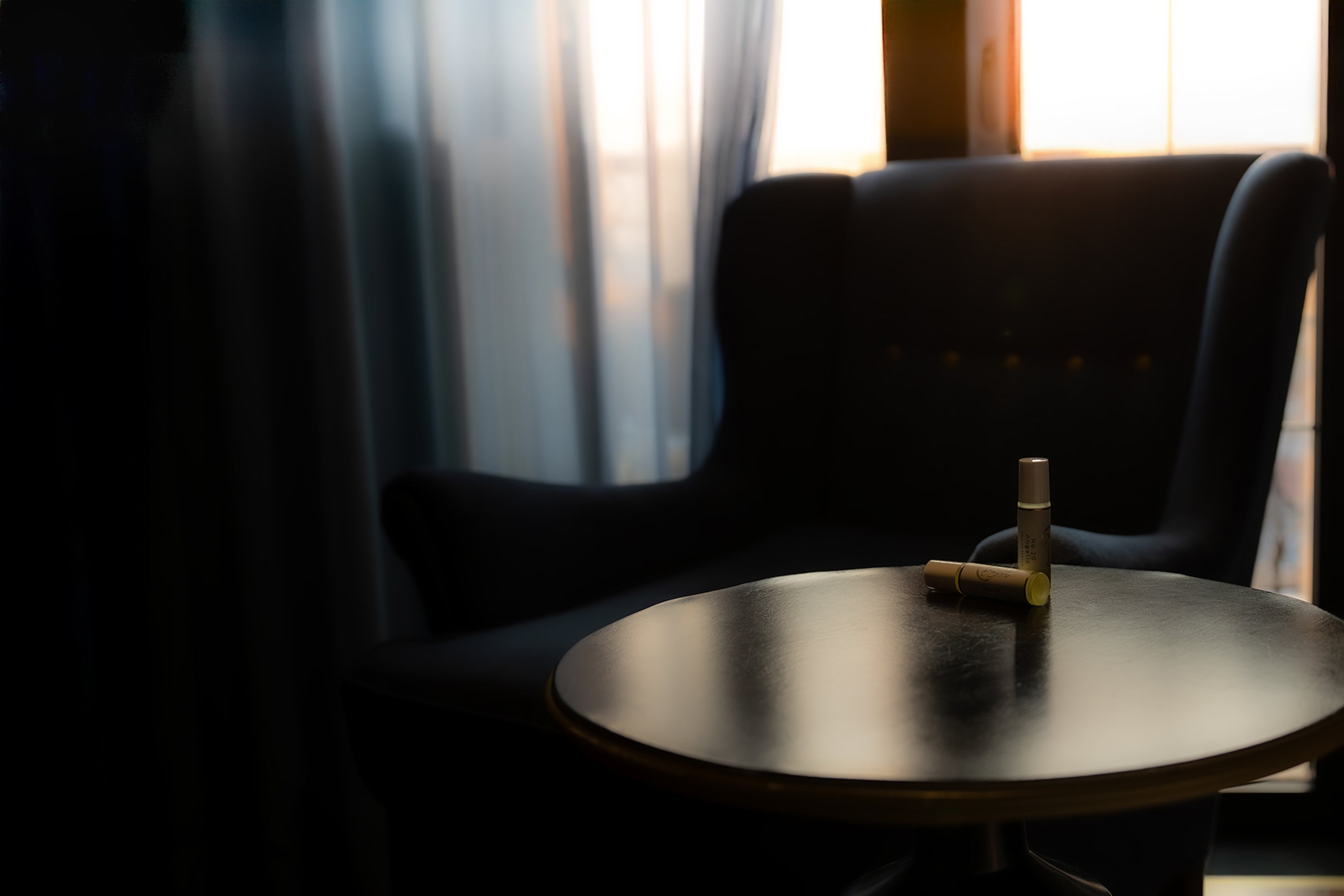 Round table with a bottle and two glasses in a dimly lit room