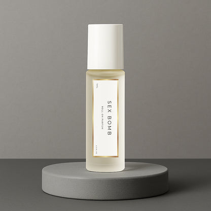 LeScent Sex Bomb perfume oil roll-on bottle on a grey concrete pedestal with a solid grey background, inspired by Viktor & Rolf Spicebomb.