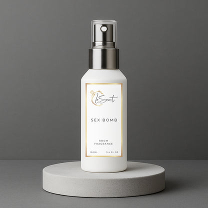 LeScent Sex Bomb room spray bottle on a grey concrete pedestal with a solid grey background, inspired by Viktor & Rolf Spicebomb.