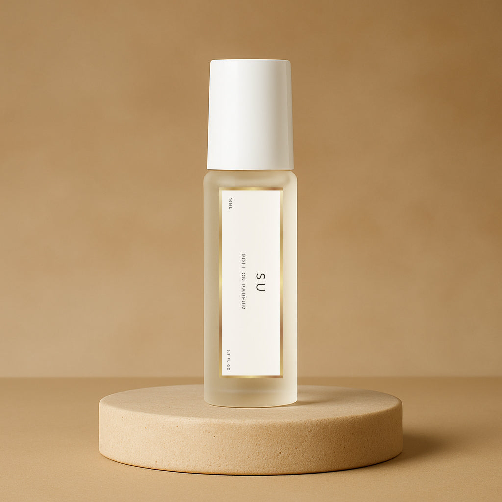 LeScent SU roll-on perfume oil bottle displayed on a warm beige pedestal with a soft tan background and gentle studio lighting, inspired by Kayali Vanilla 28.