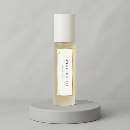 LeScent Undefeated roll-on perfume oil and parfum oil roller bottle on a soft grey background, luxury long lasting perfume oil inspired by Paco Rabanne Invictus.