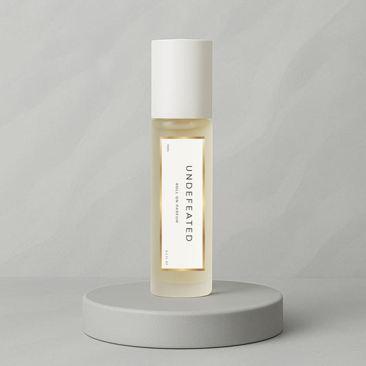LeScent Undefeated roll-on perfume oil and parfum oil roller bottle on a soft grey background, luxury long lasting perfume oil inspired by Paco Rabanne Invictus.