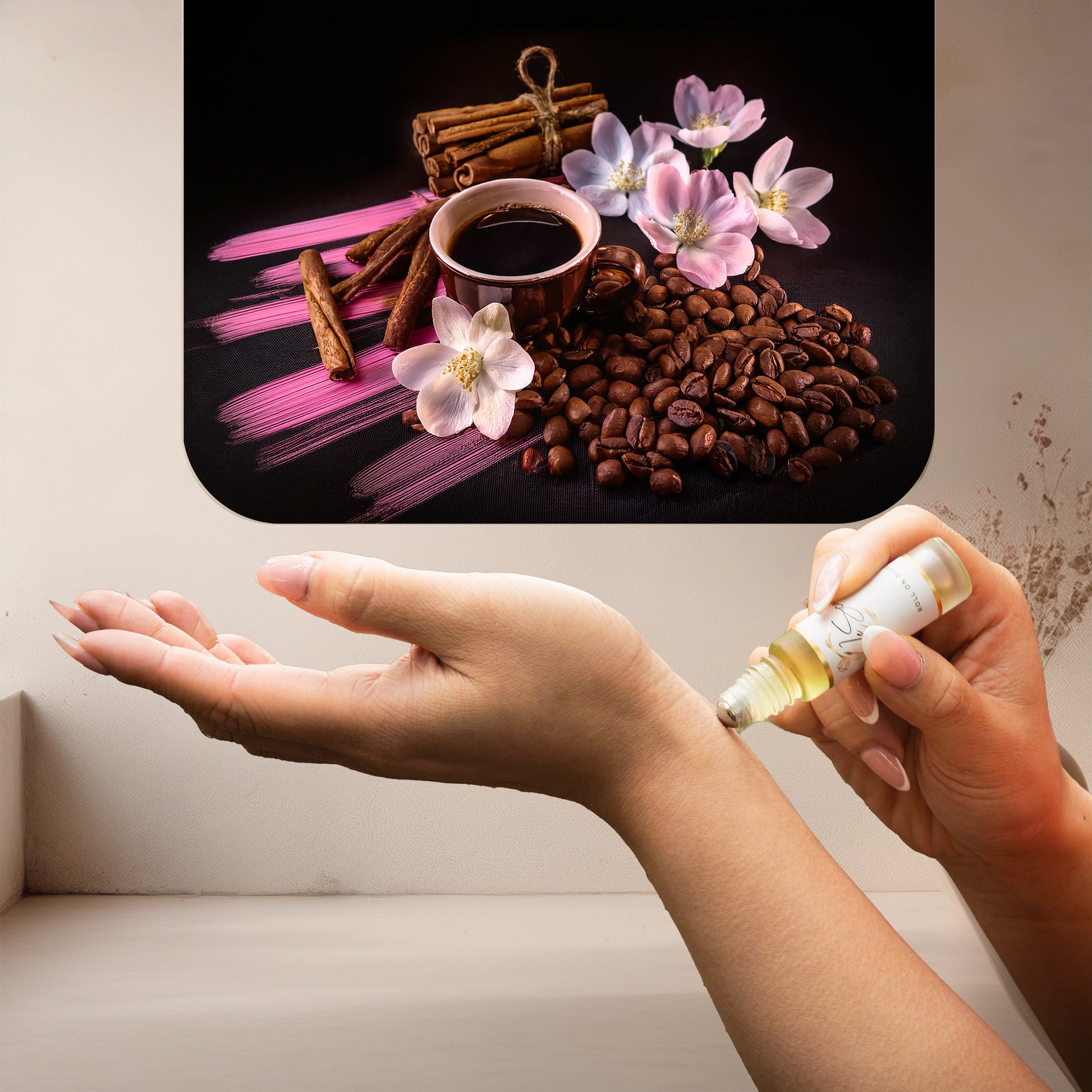 Applying LeScent Vanille Café roll-on perfume oil beside roasted coffee beans, cinnamon sticks, and pink floral accents, inspired by Yves Saint Laurent Black Opium.