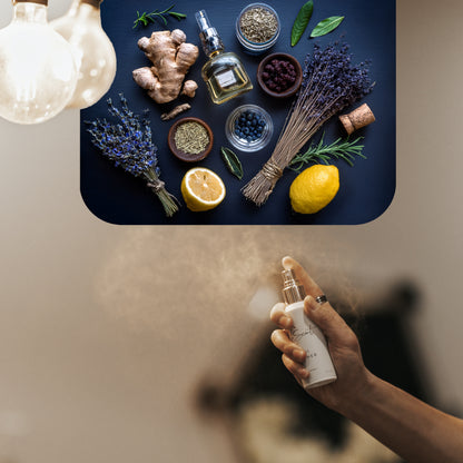 Spraying LeScent Why home fragrance freshener mist with notes of lemon, ginger, juniper, lavender, and herbs on a dark blue surface, inspired by YSL Y.