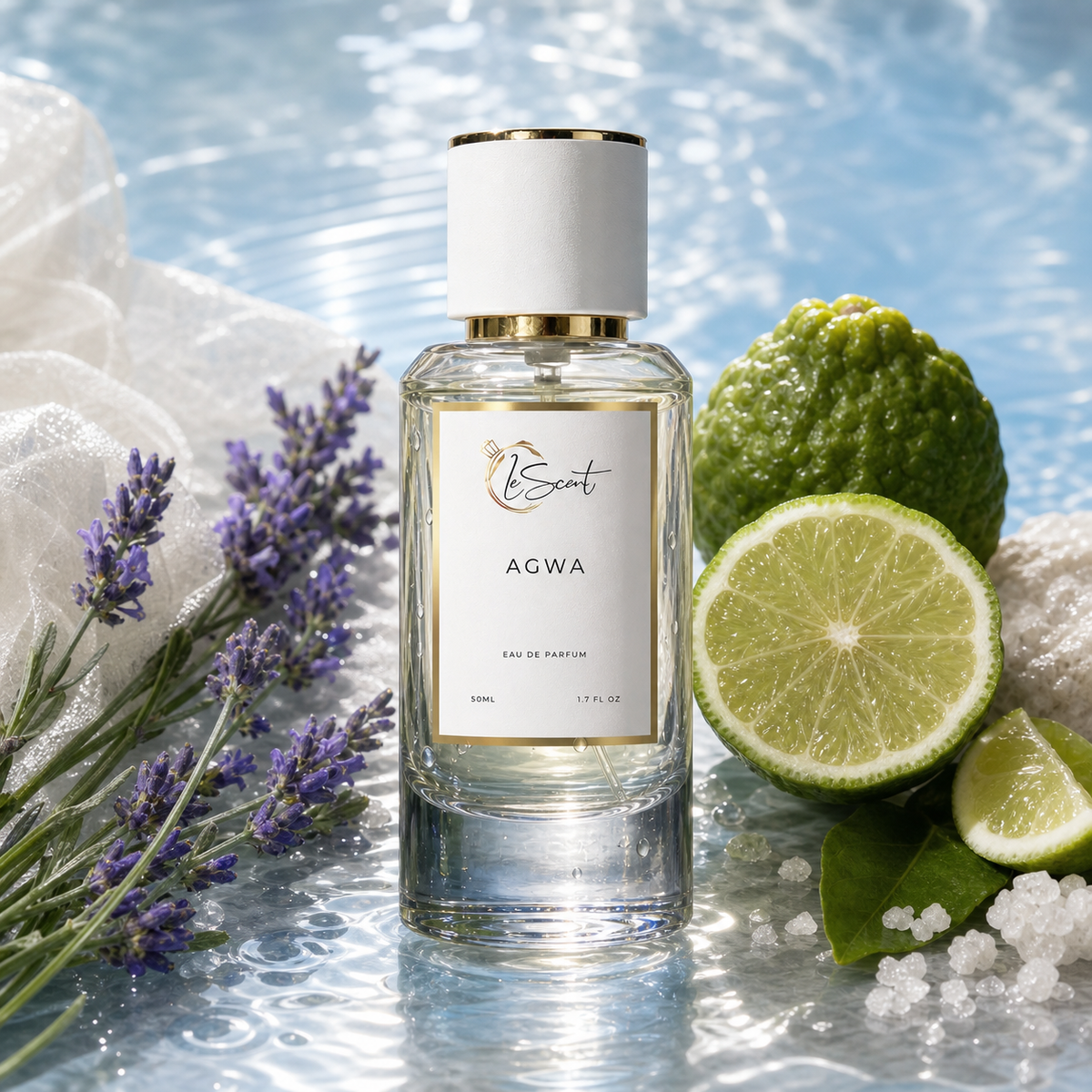 A clear glass perfume bottle labeled 'AGWA' by LeScent, styled with a white cap and gold trim, surrounded by fresh limes, lavender sprigs, and white towels on a reflective blue surface.